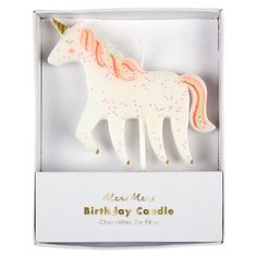 a white and pink unicorn candle in a box