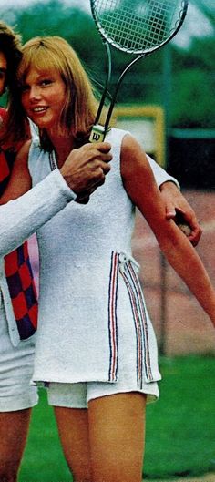 two tennis players hugging each other while holding rackets in their hands and posing for the camera