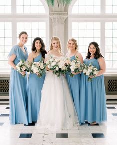 a bride and her bridesmaids in blue dresses