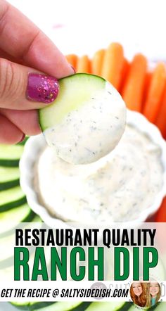 a person dipping a cucumber into a bowl of ranch dip