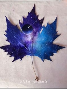 a blue and purple leaf laying on top of a table