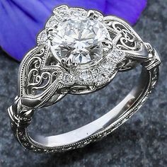 a close up of a ring with a flower in the background