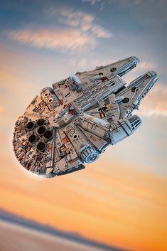 a lego millennium falcon is flying in the sky at sunset or dawn with clouds behind it