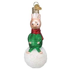 a glass ornament with a pig in a sweater on top of a snowball