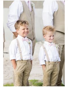 two young boys wearing suspenders and bow ties standing next to each other in front of an older man