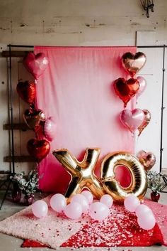 balloons and streamers decorate the backdrop for an xo celebration