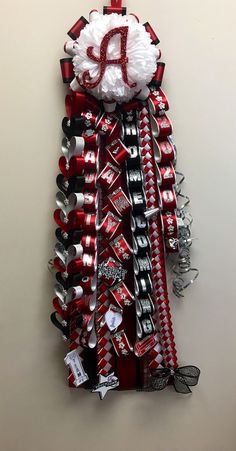 a wall hanging made out of soda cans and ribbon with the letter a on it