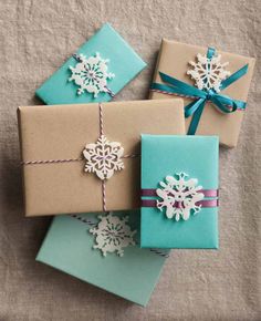 three wrapped presents with snowflakes on them, tied in twine and sitting next to each other