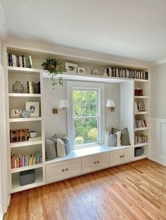 an empty room with bookshelves, windows and wooden flooring is shown in the foreground