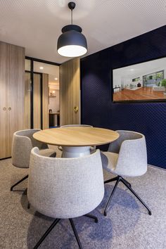 an office meeting room with chairs and a table in the center, along with pictures on the wall