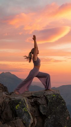 a woman is doing yoga on top of a mountain at sunset with her arms in the air