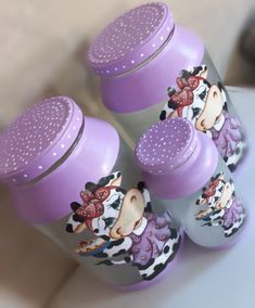 three purple and gray baby bottles sitting next to each other on a white counter top