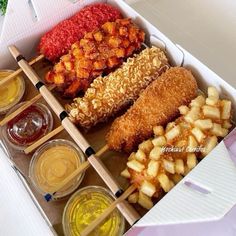 an open box filled with different types of food and dipping sauces on top of it