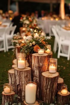 the centerpieces are made out of logs and lit candles in front of them