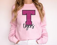 Need support your team this is customized mascot pink out shirt, buy for cheer, dance, team group or just for yourself.  Customize to your own team!    In the personalization box place letter and team mascot name for your shirt! **NOTE IMPORTANT** If you would like to add name and number or anything to back please add the link below to your cart as well.  Thank you! https://www.etsy.com/OffthehookboutiqueCo/listing/1275912718/add-on-print-to-existing-order?utm_source=Copy&utm_medium=ListingManager&utm_campaign=Share&utm_term=so.lmsm&share_time=1661023552487 -----------------How to Order--------------------------- 1. In first drop down pick size of t-shirt. 2. in second drop down pick style of shirt 3. Repeat for additional shirts.   5. Add to cart and proceed to checkout. Bulk discounts av Pink Crew Neck T-shirt For Sports Events, Pink Cotton T-shirt With Team Spirit Style, Team Spirit Pink T-shirt With Team Name, Pink T-shirt With Team Name For Sports Season, Sporty Pink T-shirt For Cheerleading, Team Pink, Team Mascots, Pink Out, Cheer Team