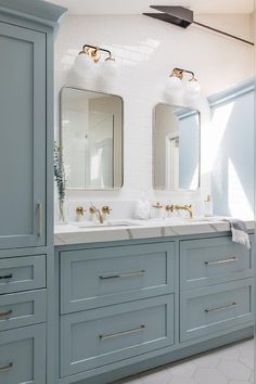 a bathroom with blue cabinets and two sinks