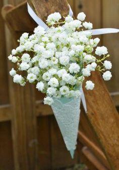 a bouquet of white flowers sitting on top of a wooden bench