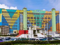 many cars are parked in front of colorful buildings