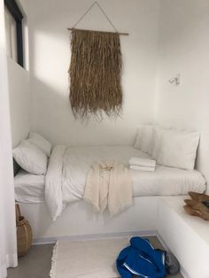 a bed room with a neatly made bed next to a wall hanging on the wall