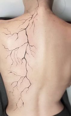 the back of a woman's upper body is shown with branches growing out of it