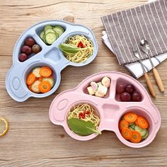 two plastic bowls filled with food on top of a wooden table next to an orange slice