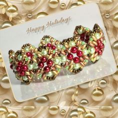 two bracelets with pearls and beads on top of a white card that says happy holidays