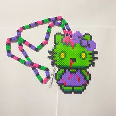 an image of a beaded hello kitty ornament hanging on a wall with beads