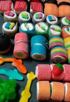 a table topped with lots of different types of sushi rolls and other food items