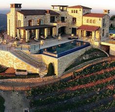 an aerial view of a large house with a swimming pool in the middle of it