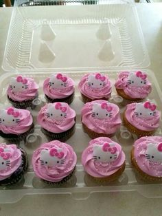 hello kitty cupcakes with pink frosting in a plastic container on a table