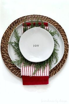 a white plate topped with greenery next to a red napkin