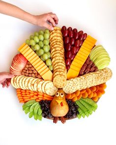 a turkey shaped platter filled with cheese, crackers, grapes, and nuts