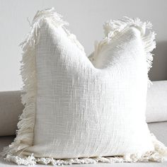 a white pillow sitting on top of a couch