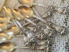 silver spoons are lined up on a table