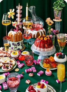 a table topped with cakes and desserts covered in icing