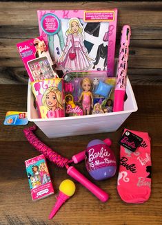 the contents of a barbie doll's birthday gift box are displayed on a wooden table