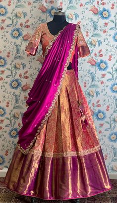 a mannequin wearing a purple and gold lehenga