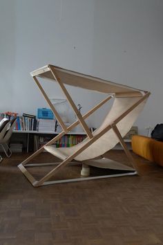 a chair sitting on top of a hard wood floor next to a book shelf filled with books