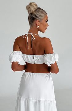 Cut from crisp cotton blend fabric, the Carmen set is made for brunching on balmy days. This top has a cropped fit with a delicate halterneck ties to the centre and pretty puff sleeves that sit off the shoulder. With all-over ruched detailing, the look is complete with a flirty corsage flower to the centre. Pair her with the Carmen maxi skirt for the prettiest fit you'll wear this season.



Colour: White.

Non stretch cotton blend fabric.

Ruched detail.

Puff sleeves that sit off the shoulder. Homecoming Dresses Corset, White Dress Spring, Pink Monochrome, Midi Dress Wedding Guest, Lingerie Heels, Long Sleeve Homecoming Dresses, Split Long Dress, Homecoming Dresses Long, Maxi Dress Sale