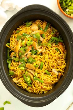 a bowl filled with noodles and vegetables on top of a table