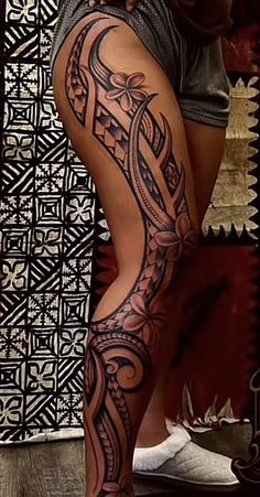 a woman's leg with an intricate tattoo design on the thigh and lower half