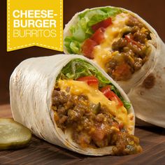 two burritos with meat, cheese and lettuce on a cutting board