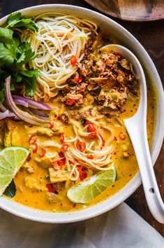 a bowl filled with noodles, meat and vegetables