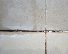 the corner of a tile wall that has been stripped off with water droplets on it