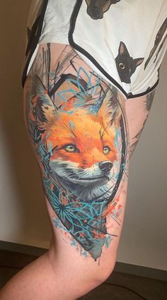 a person with tattoos on their legs and an orange fox in the middle of his leg