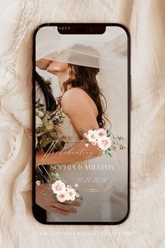 an iphone case with a wedding photo on the back and flowers in the front, sitting on a white blanket