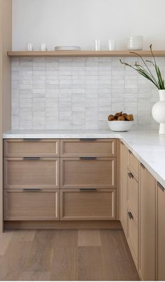 a kitchen with wooden cabinets and white marble counter tops