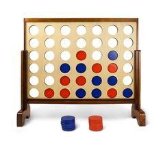 a giant four in a row board game with blue, red and orange discs around it