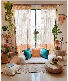 a living room filled with furniture and lots of plants on the windows sills