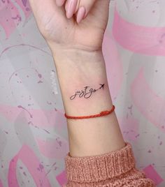 a woman's wrist tattoo with the word joy written in cursive writing